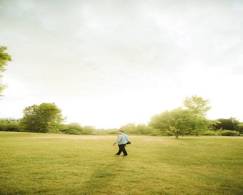 A person walking calmly in a bright green park